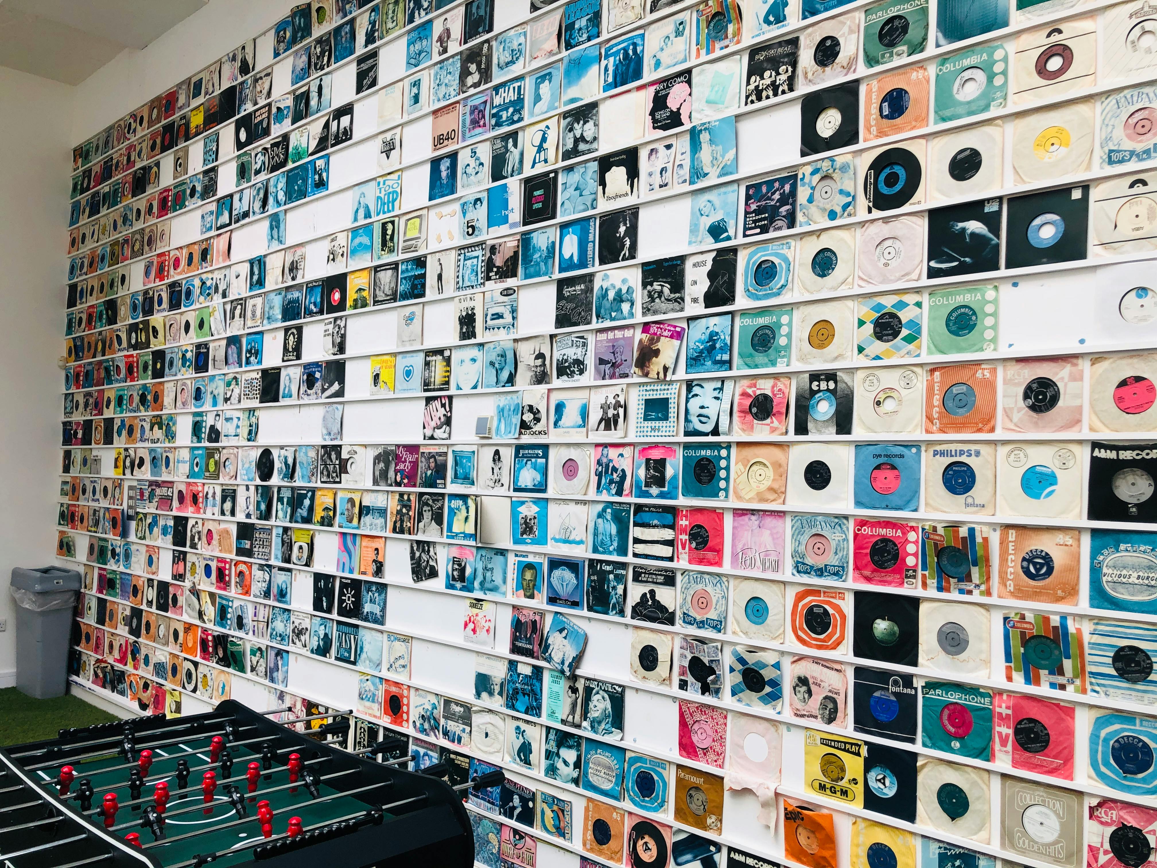 vintage vinyl discs hanging on wall near foosball in store