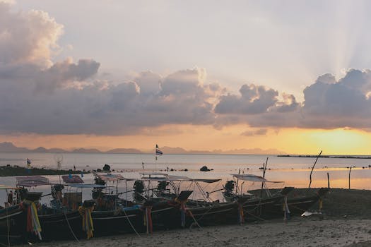 Traditional boats rest on a peaceful coast at sunset, capturing the serene beauty of nature.