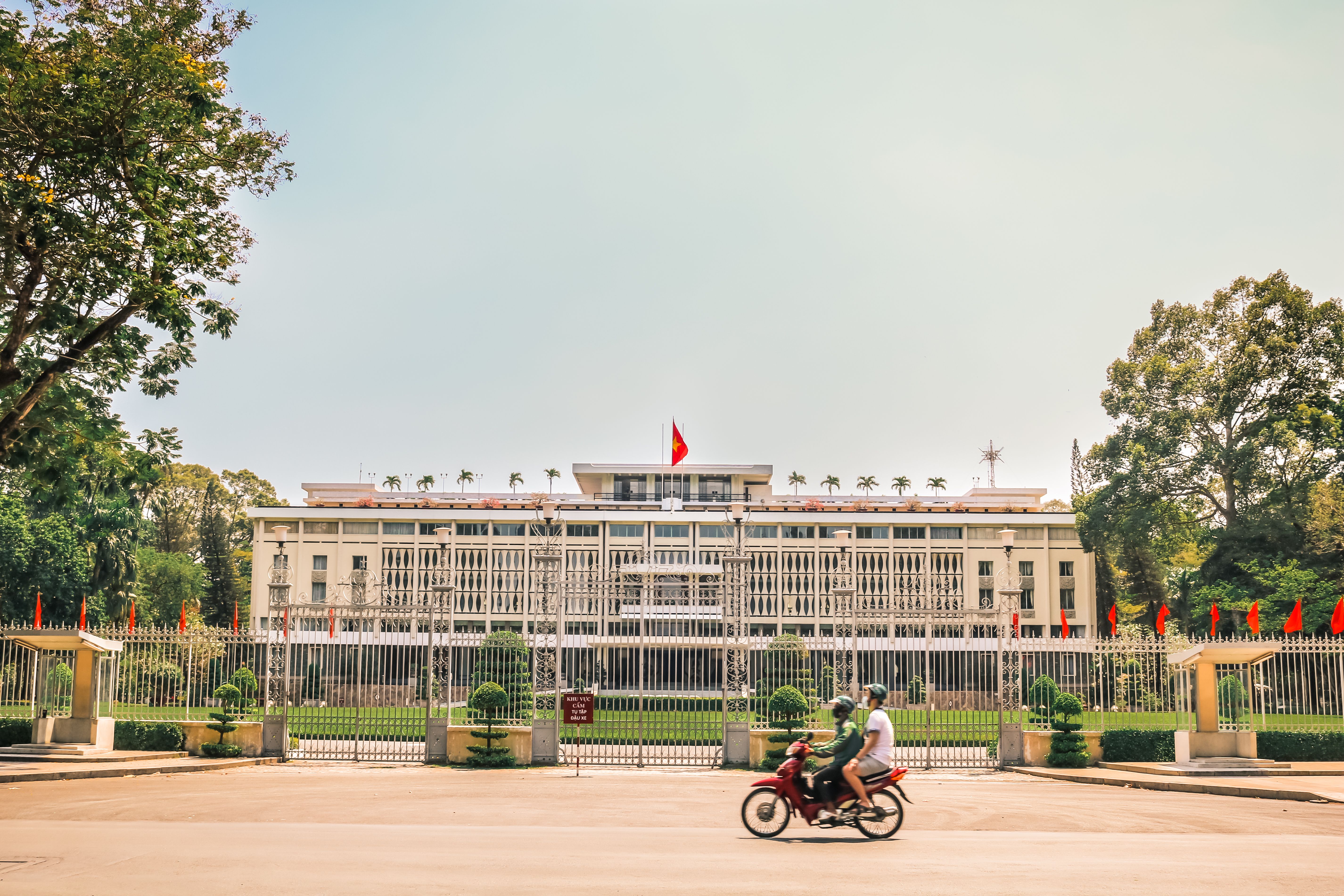 Vibrant view of Independence Palace with motorcyclists in Saigon, Vietnam