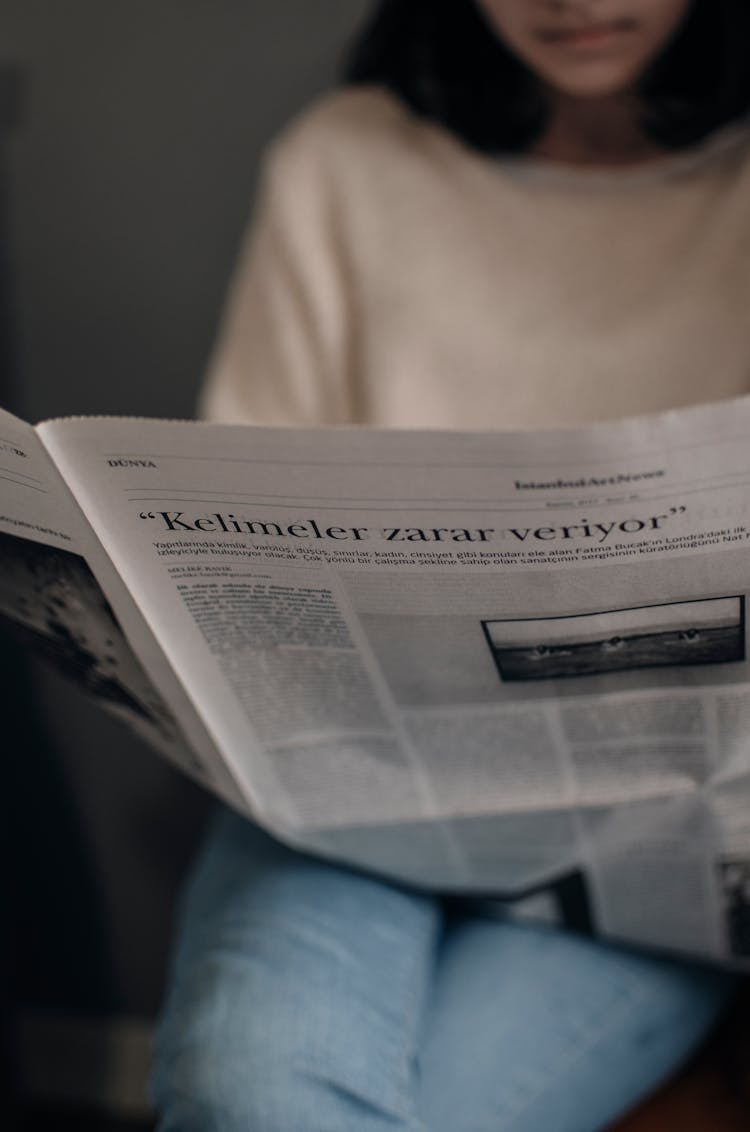 Crop Woman Reading Newspaper In Room