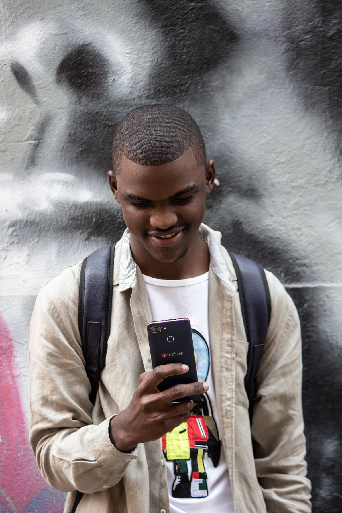 Smiling Nigerian man using his smartphone