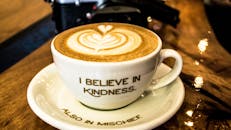 咖啡拿铁艺术的特写，陶瓷杯盘上印有鼓舞人心的信息