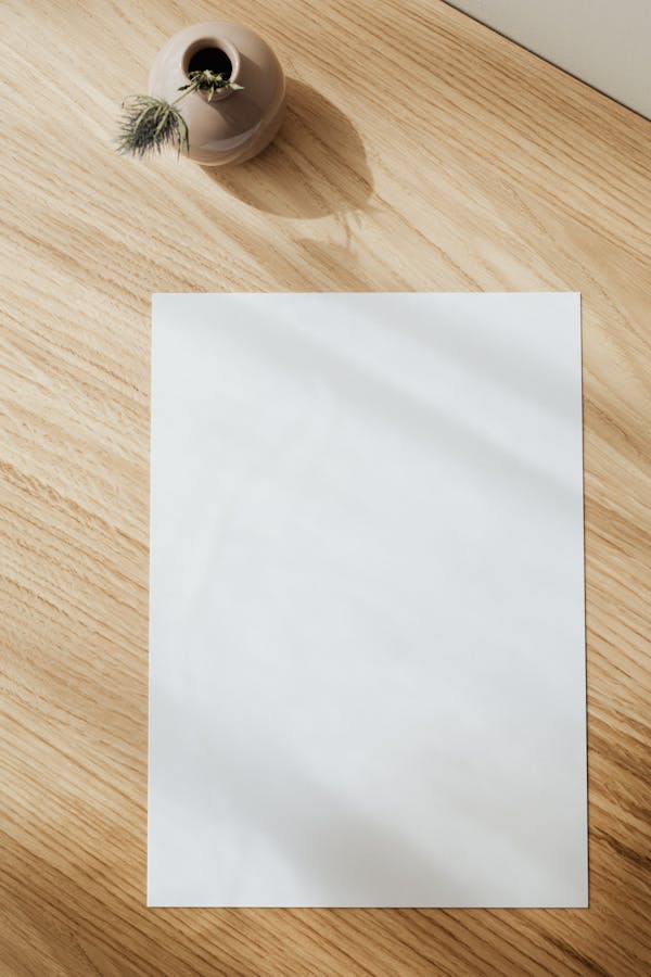 Blank white paper sheet on wooden table