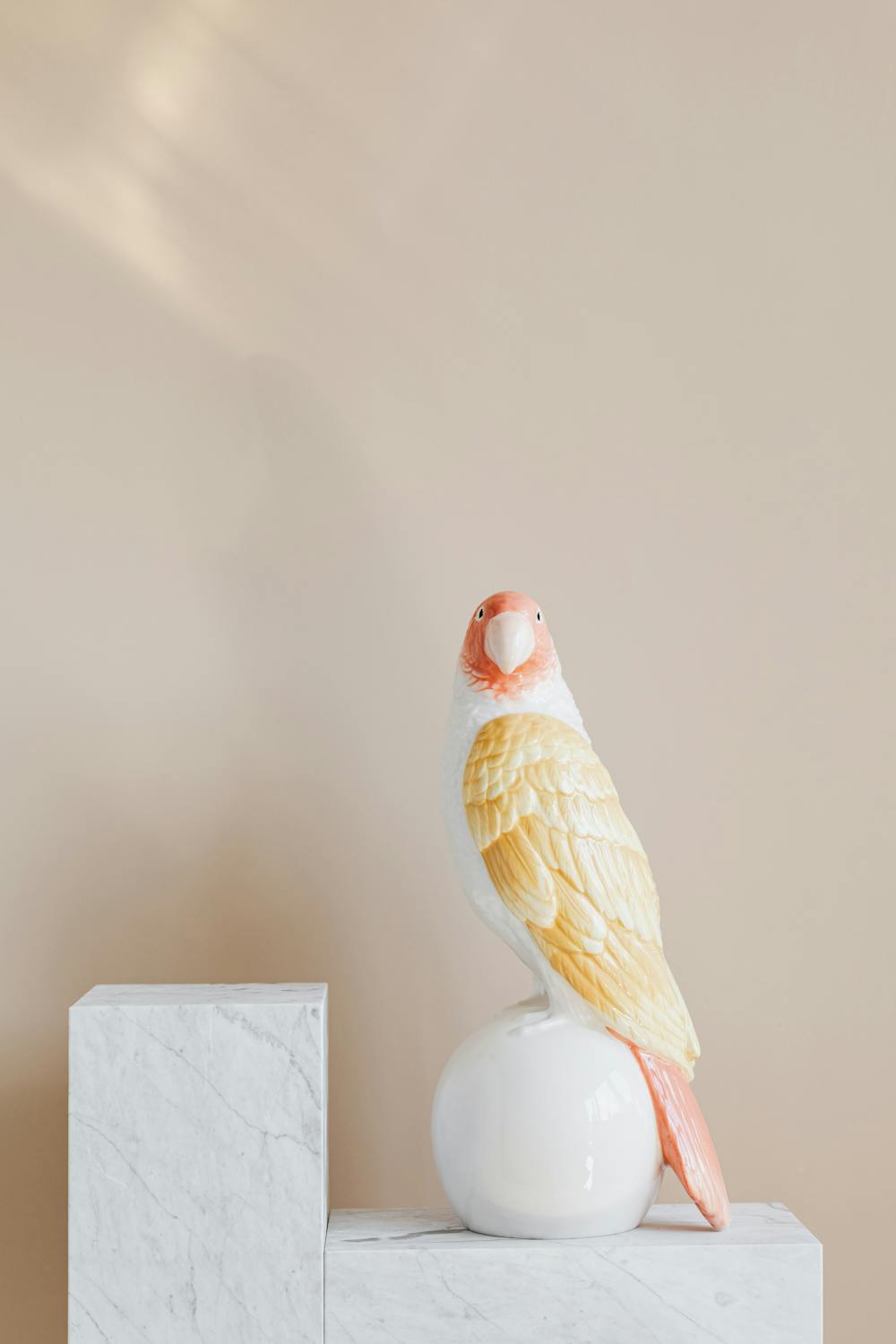 Statuette in shape of parrot on marble stand · Free Stock Photo