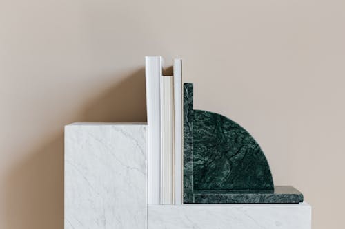 Marble patterned cabinet decorated with stylish bookend and set of magazines