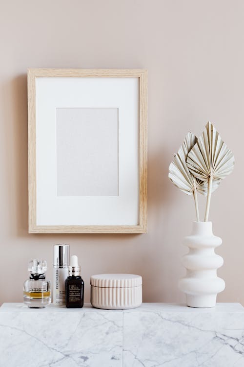 Stylish minimalistic composition of cosmetics vase and wall frame