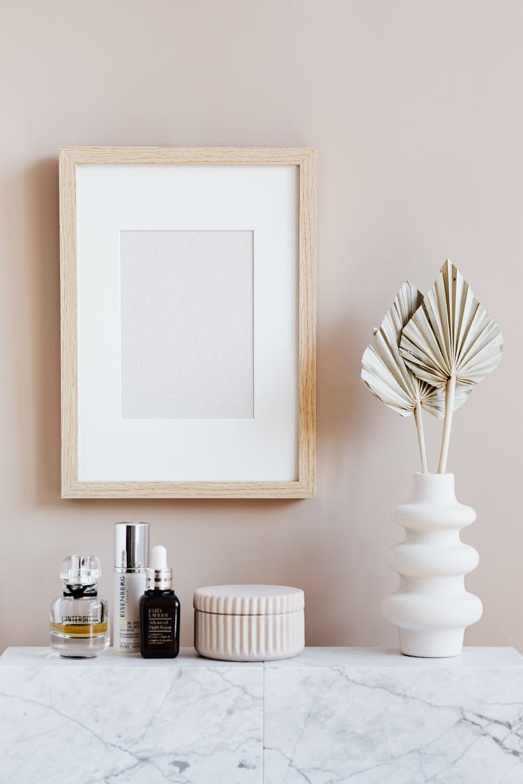 Stylish Minimalistic Composition Of Cosmetics Vase And Wall Frame