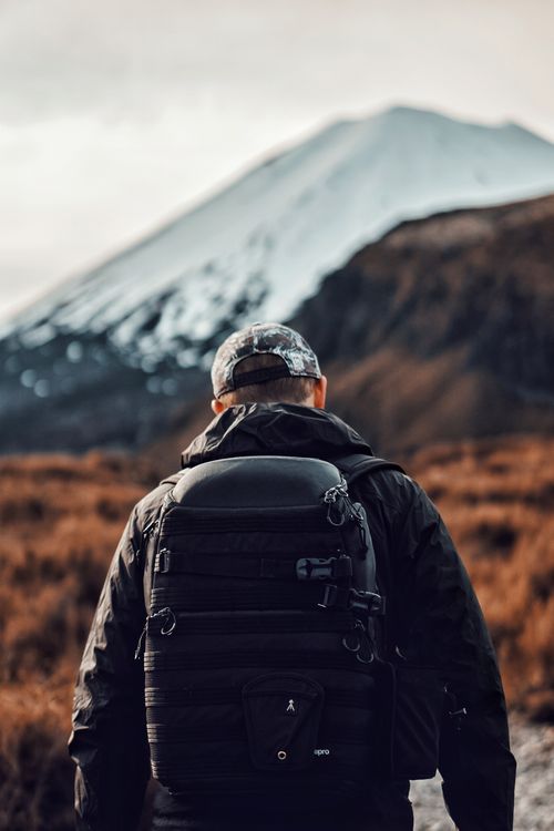 Hiker facing a snow-capped peak — photo by Gantas Vaičiulėnas on Pexels