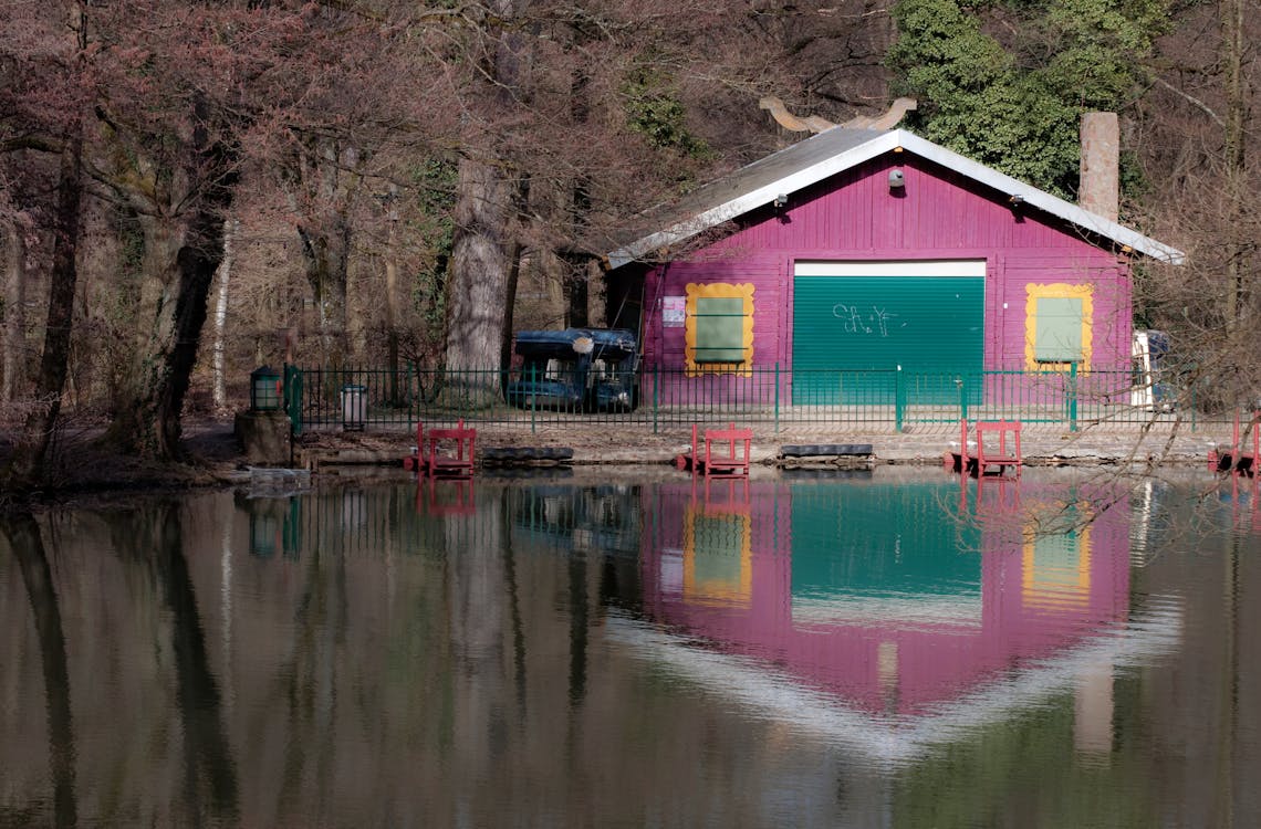 Calm Body of Water Near Pink Painted House