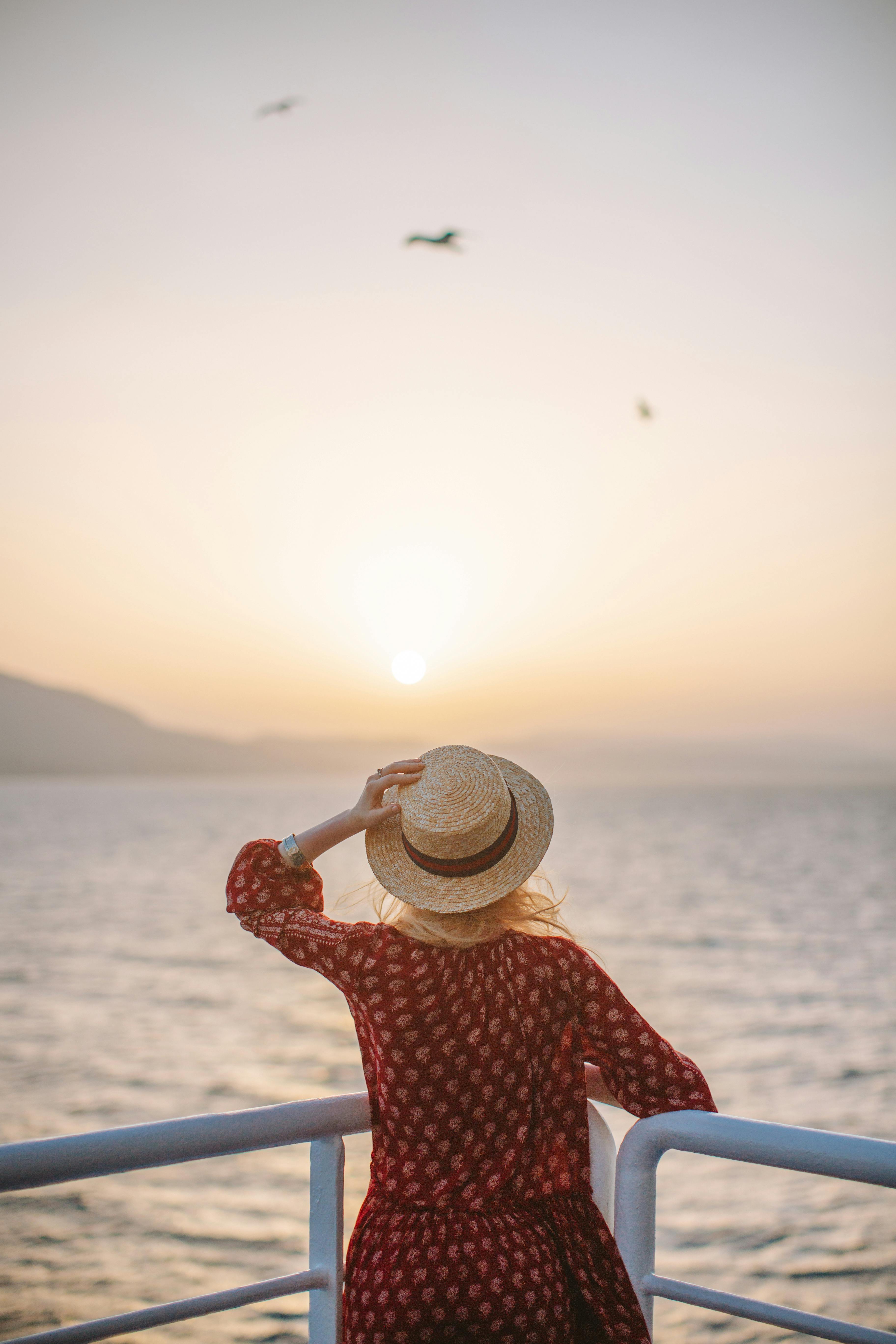 woman in a red dress looking at the sunset