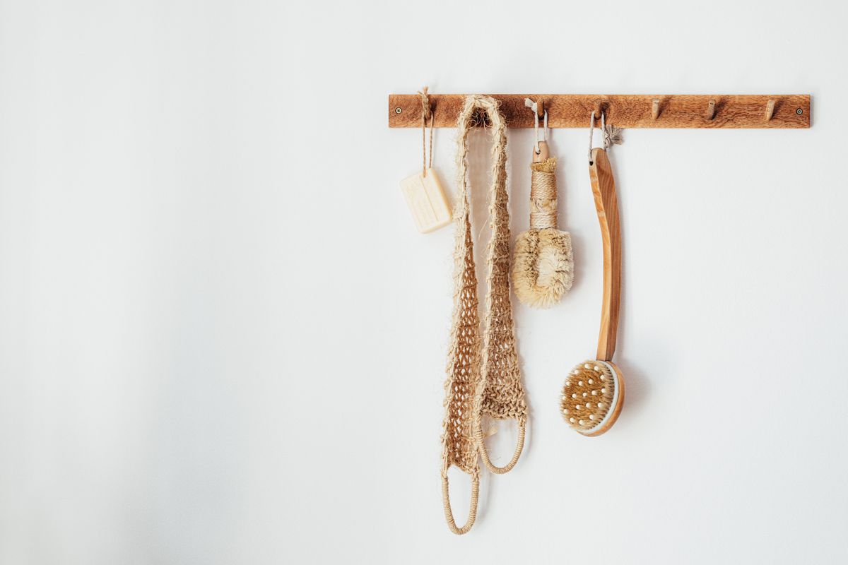 Bathroom accessories neatly hung on a wooden wall rack