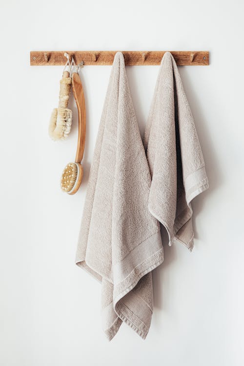 Free Wooden hanger with towels and body brushes Stock Photo