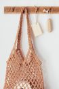 Wooden hanger with toiletries and string bag