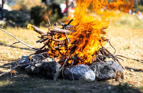 Free Close-up of a campfire with logs and stones outdoors, showcasing vivid flames. Stock Photo