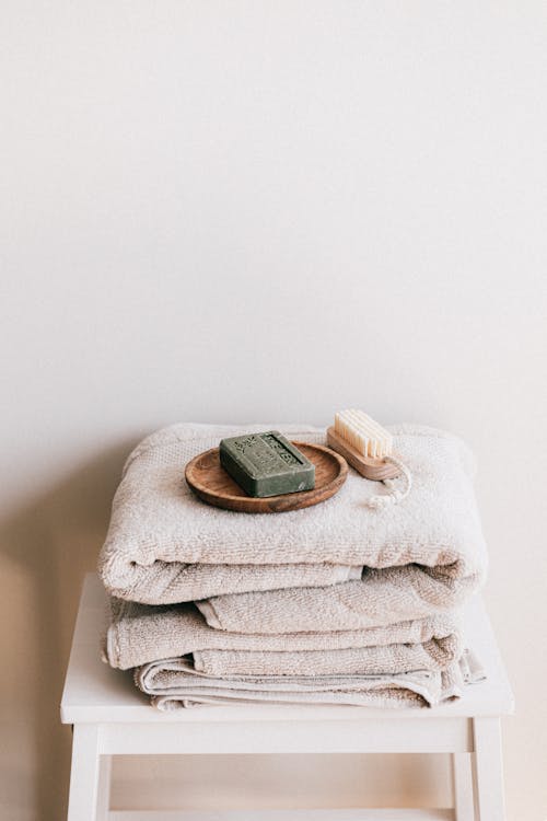 Natural toiletries and towels on stool