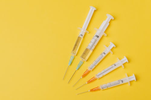 Syringes of different sizes on yellow background