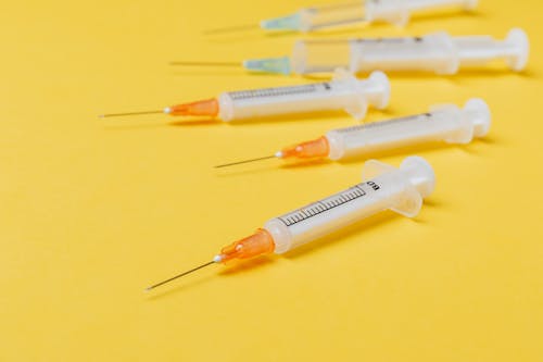 Syringe injectors placed on yellow surface