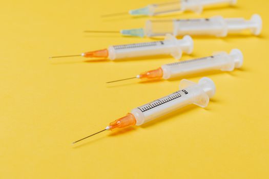 Syringe injectors placed on yellow surface