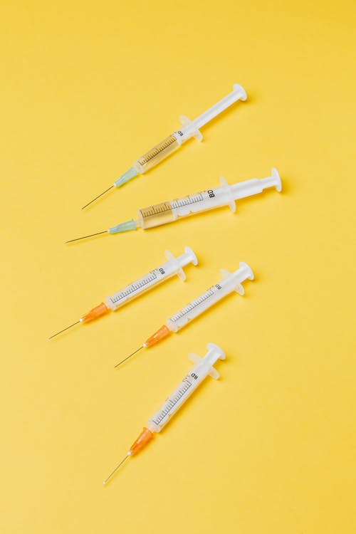 Syringes with medication on yellow surface