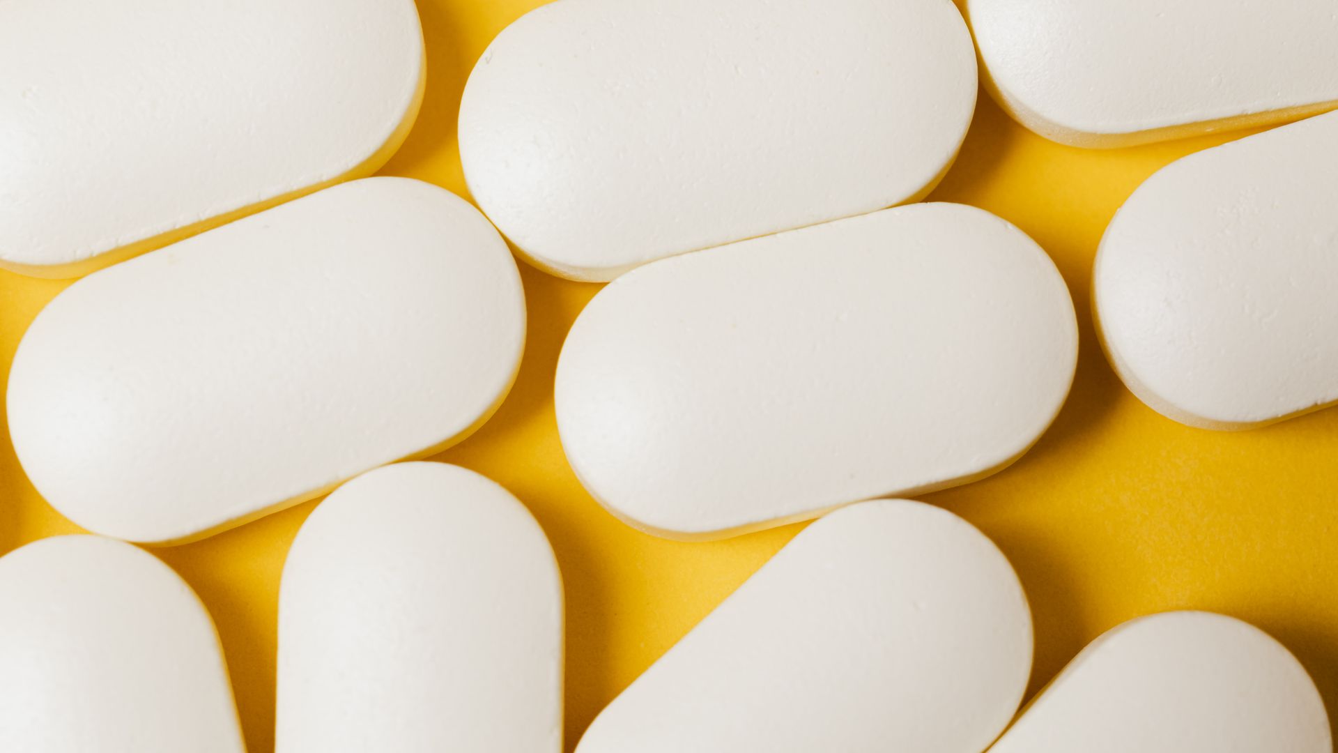 Modafinil Long Term Effects: Unlocking the Secrets From above closeup of white ellipse shaped medical pills placed on bright yellow surface — modafinil long term effects