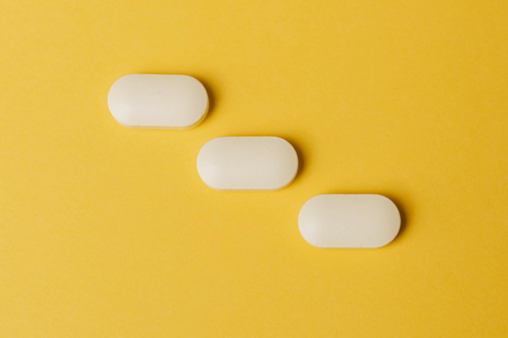 Set of pills on yellow surface