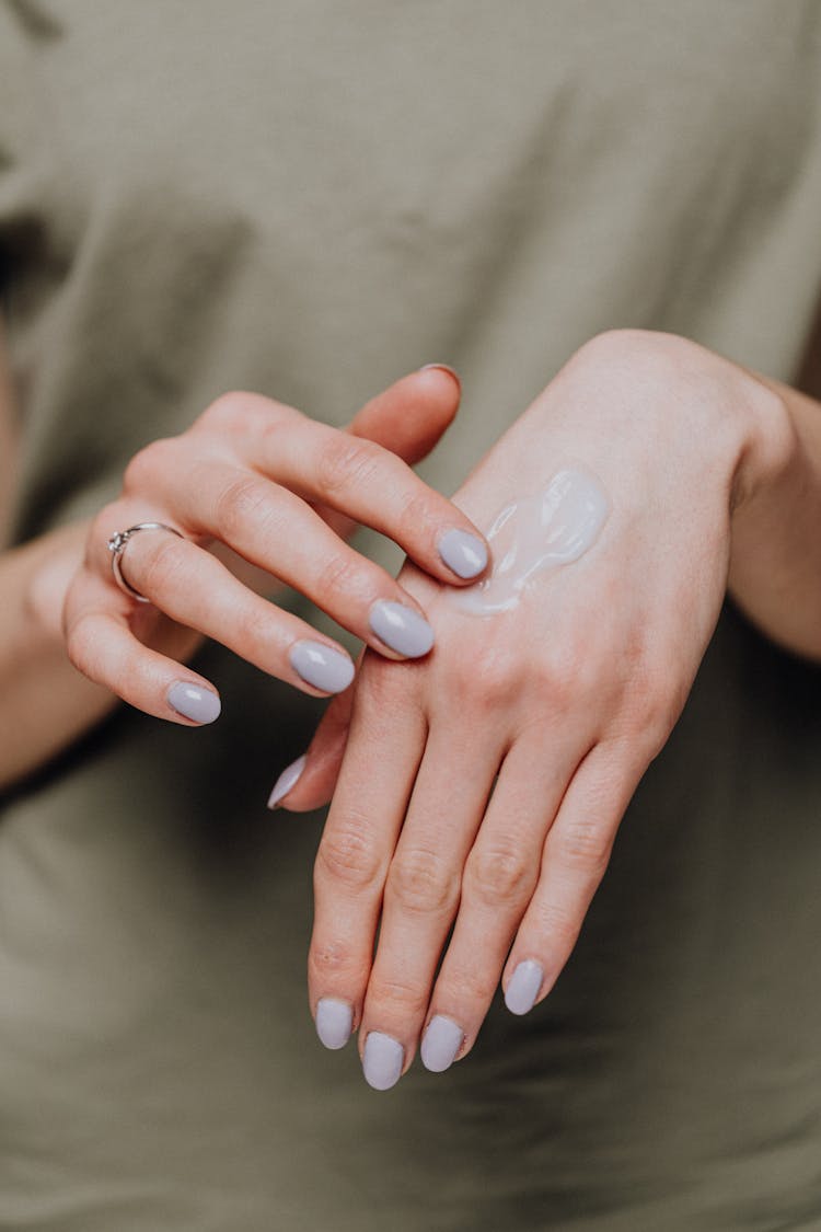 Crop Woman Applying Cream On Hands