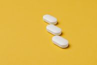 Set of white pills on yellow background