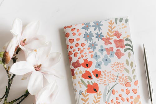 Free Notebook with pen near Magnolia flower Stock Photo