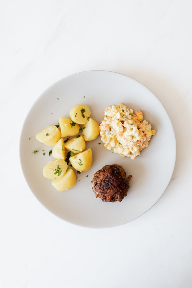 Fried Cutlet Garnished With Boiled Potato And Salad