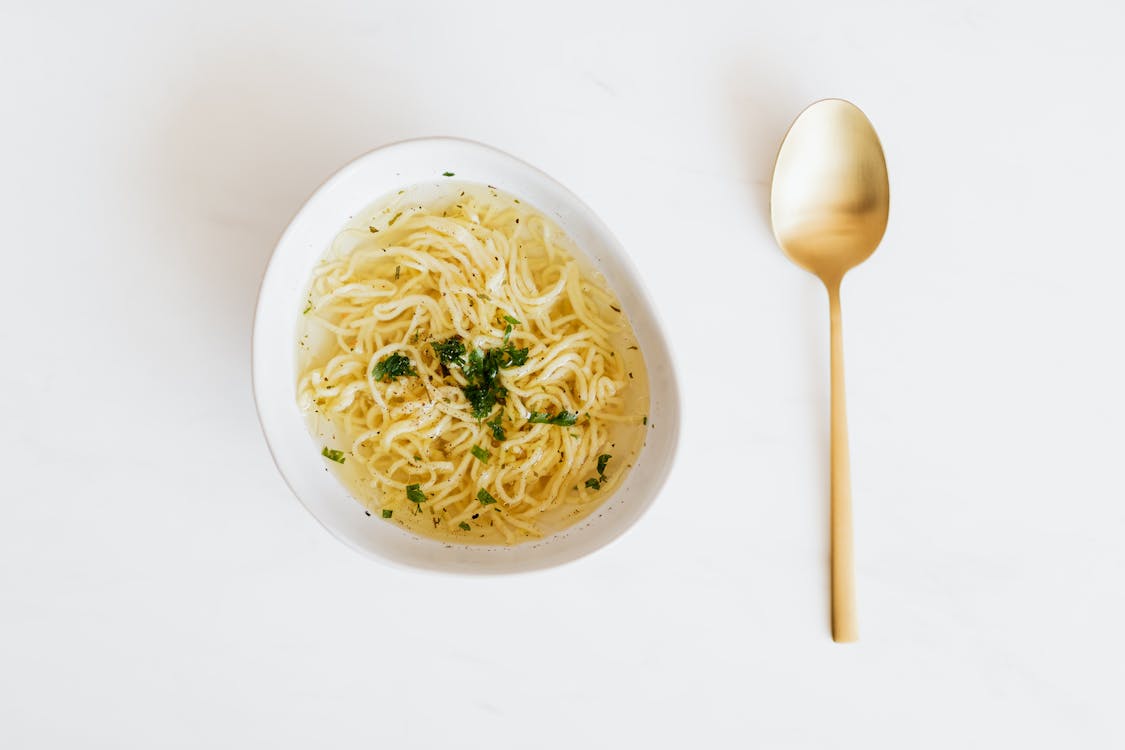 Bowl of noodles with golden spoon