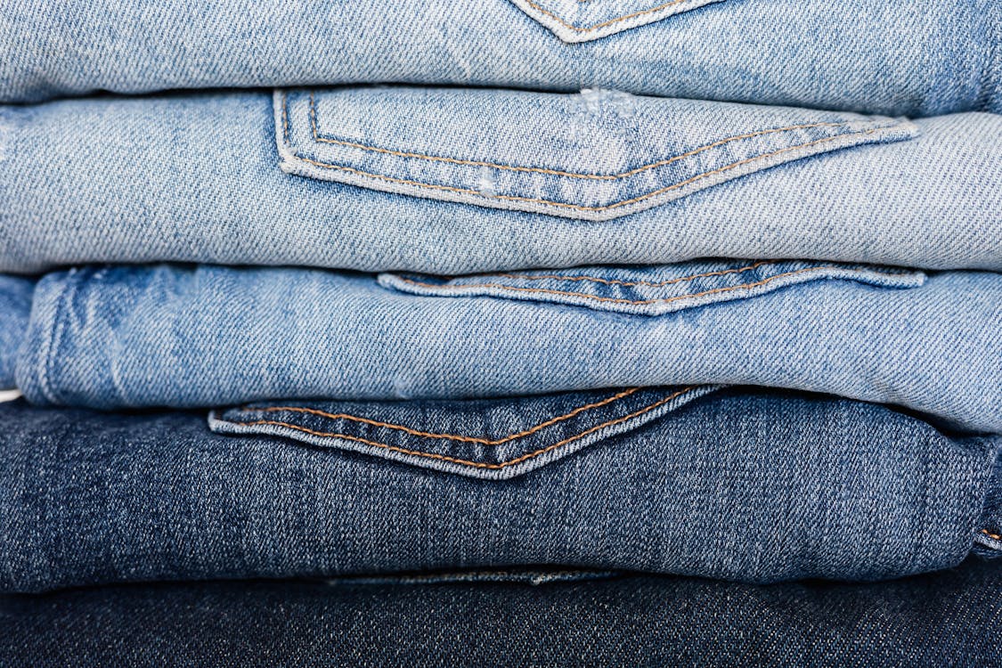Free Closeup of stack of blue denim pants neatly arranged according to color from lightest to darkest Stock Photo