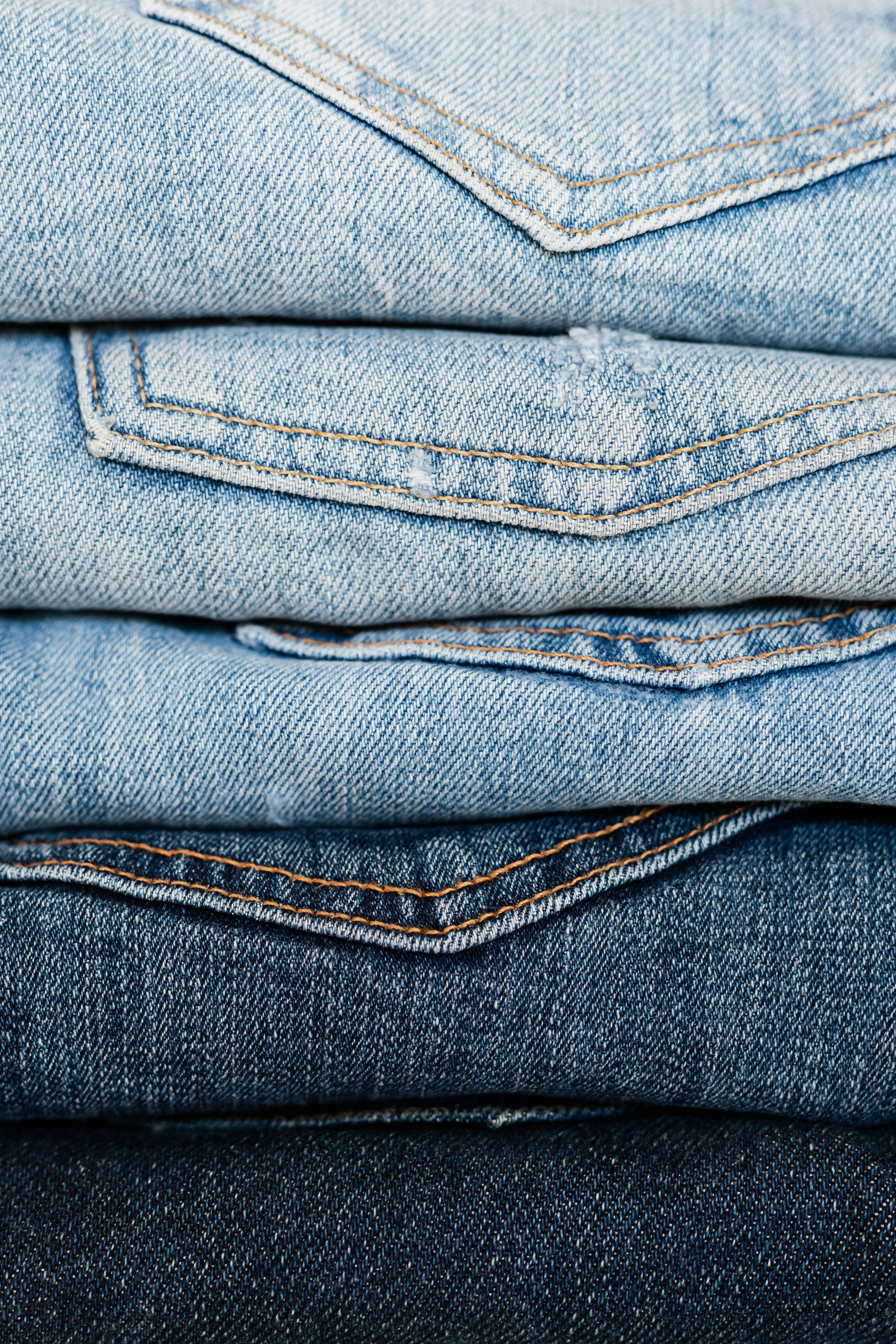 stack of blue jeans arranged by color