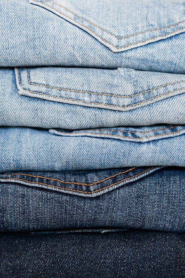Stack of blue jeans arranged by color