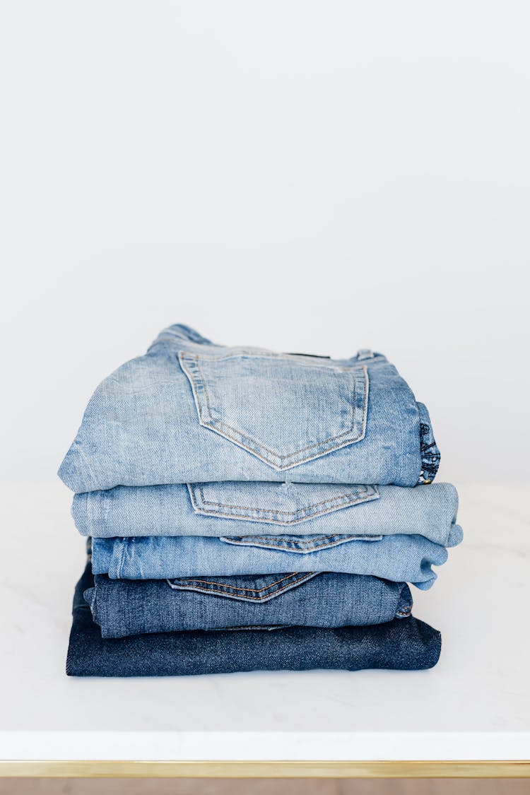 Stack Of Jeans On White Shelf