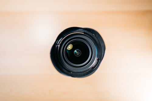 Lens of black photo camera placed on table