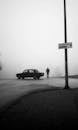 Monochrome Photo of Car Parked near Person