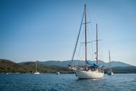 White and Black Boat Surrounded by Body of Water Under Blue Sky