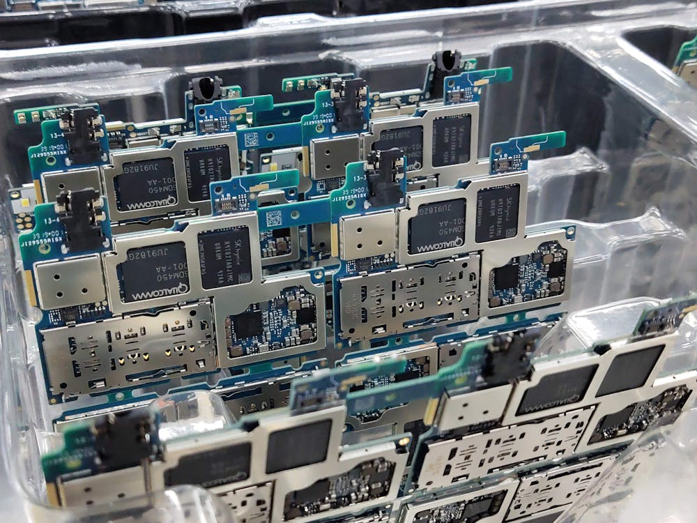 Free From above of circuit boards of modern smartphones placed in plastic box in electronics factory Stock Photo
