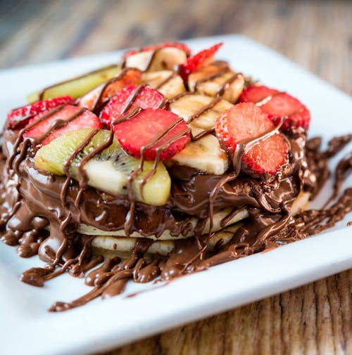 Close-up Photo of Pancakes with Sliced Strawberry and Drizzled Chocolate 