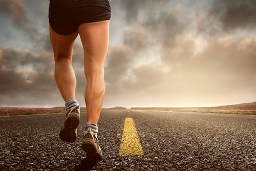 Low Angle Photography Man Walking on Asphalt Road