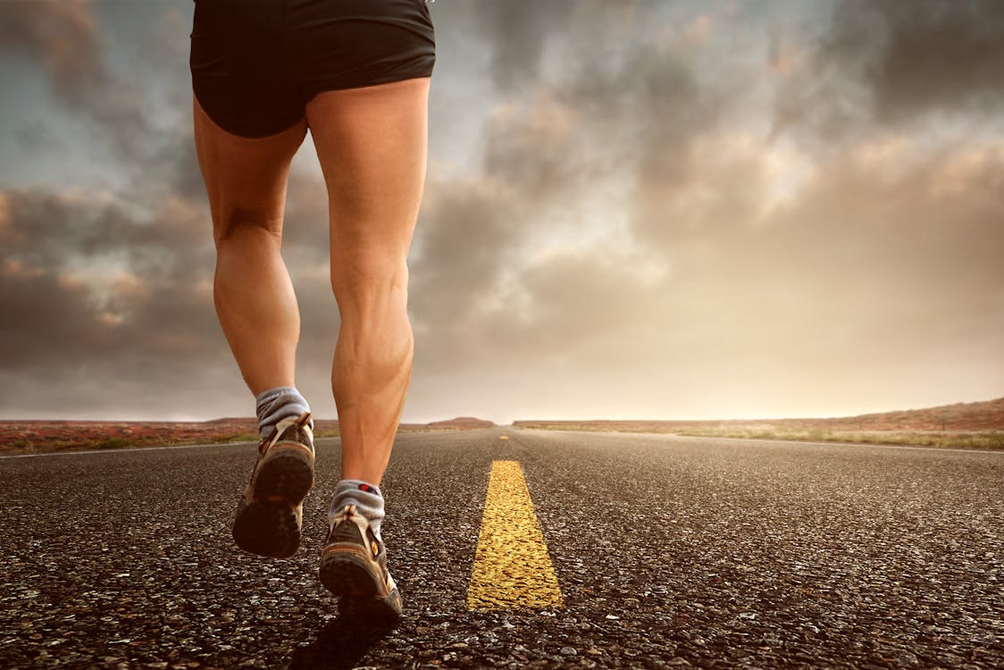 Free Low Angle Photography Man Walking on Asphalt Road Stock Photo