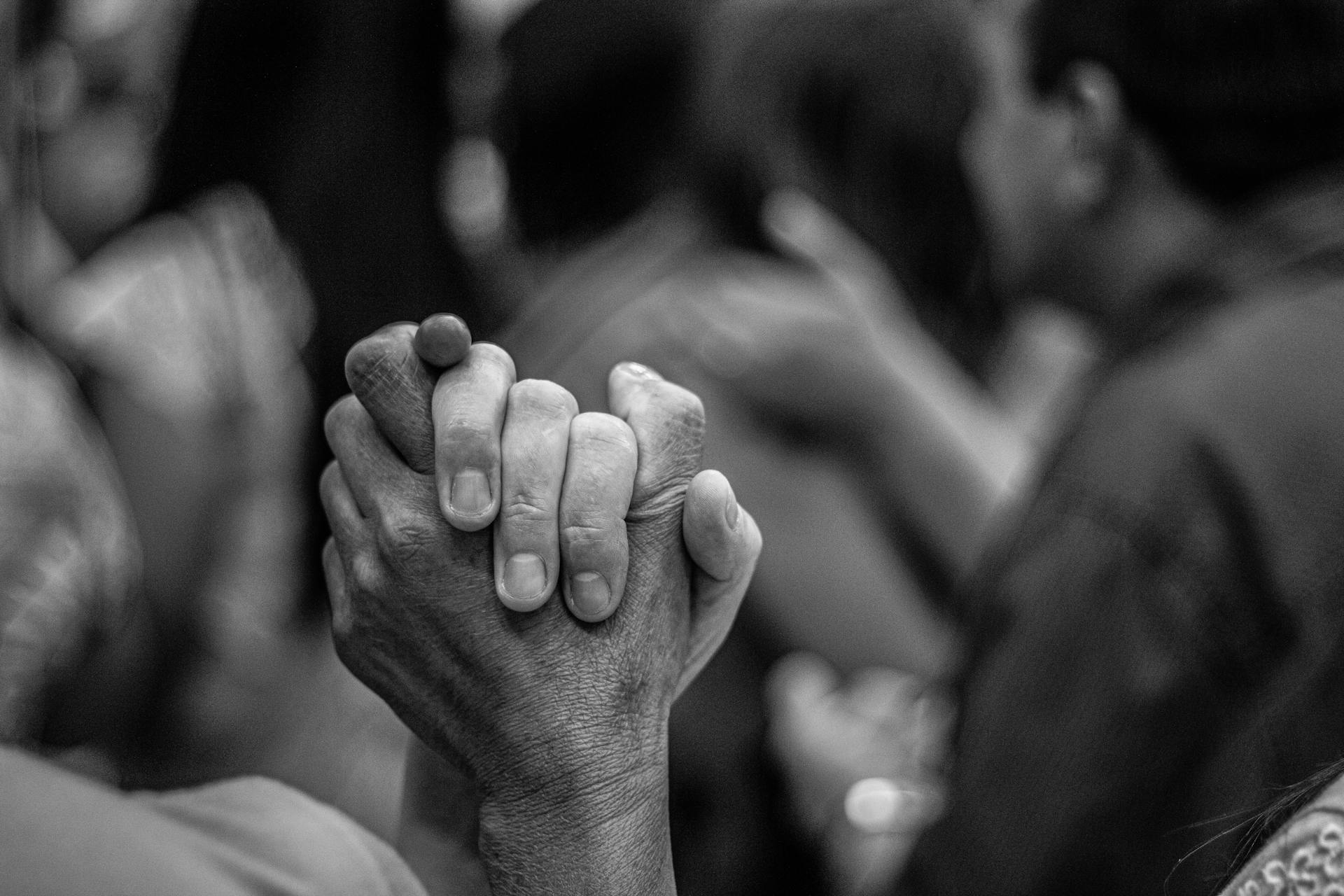 Artistic black and white photo of joined hands symbolizing unity and peace.