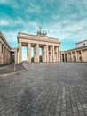 From below of aged masonry gate with quadriga statue on top under blue cloudy sky in Berlin