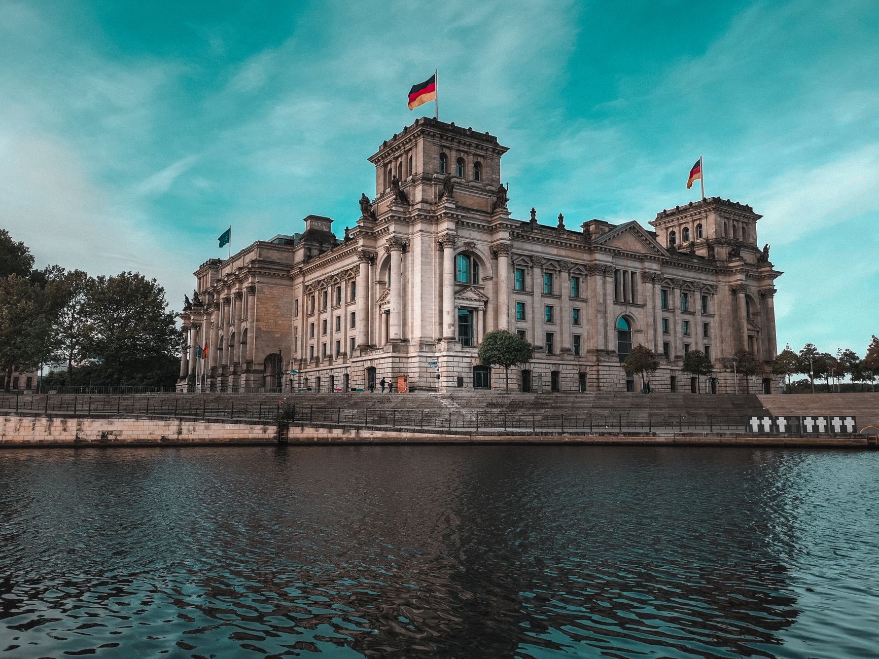Adembenemend uitzicht op het Reichstag in Berlijn naast de rivier, die zijn architectonische pracht toont.
