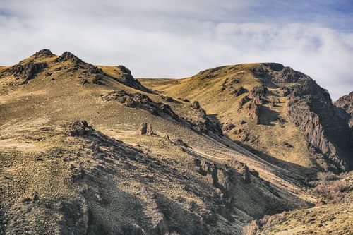 Free Scenic view of rough brown mounts with pointed peaks under cloudy sky in daytime Stock Photo
