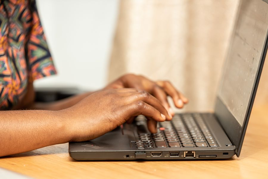 Close-up of hands typing on a laptop