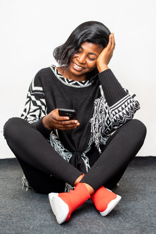 Photo of Woman Smiling While Using Black Smartphone