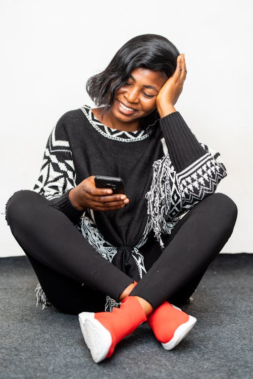 Photo of Woman Smiling While Using Black Smartphone