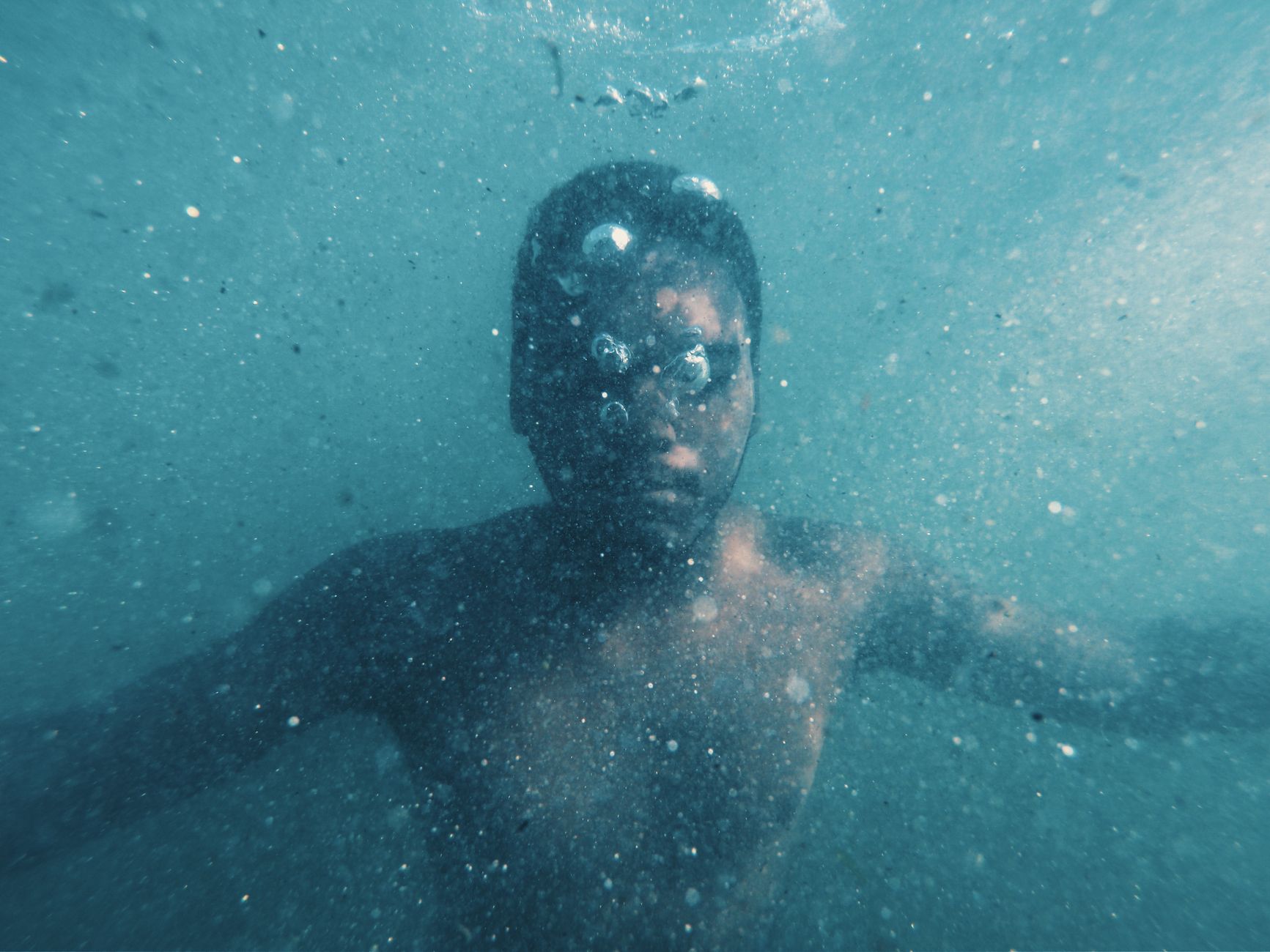 A dramatic underwater portrait capturing the solitude of a male diver.