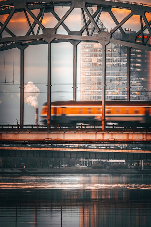 Fast train driving on railway on bridge in city